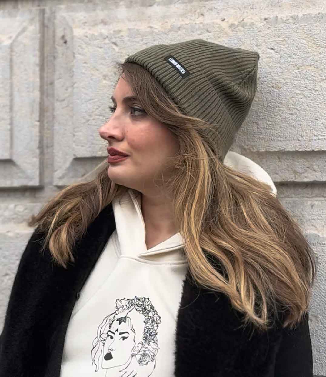 Personne portant un bonnet éthique en coton biologique certifié GOTS et FairWear, bonnet doux et tendance pour l’automne et l’hiver, bord pliable, taille unique, plusieurs coloris disponibles.