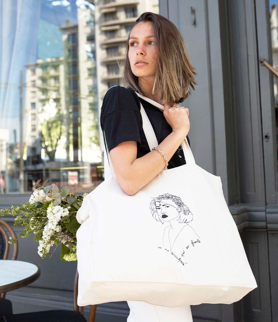Cabas femme en coton bio écru avec un imprimé noir représentant une femme forte inspirée d’une reine d’Amérique latine, accompagné de l’inscription “No me disculparé por ser fuerte”. Modèle Lupita, imprimé à Lyon par la marque éthique Leonor Roversi.