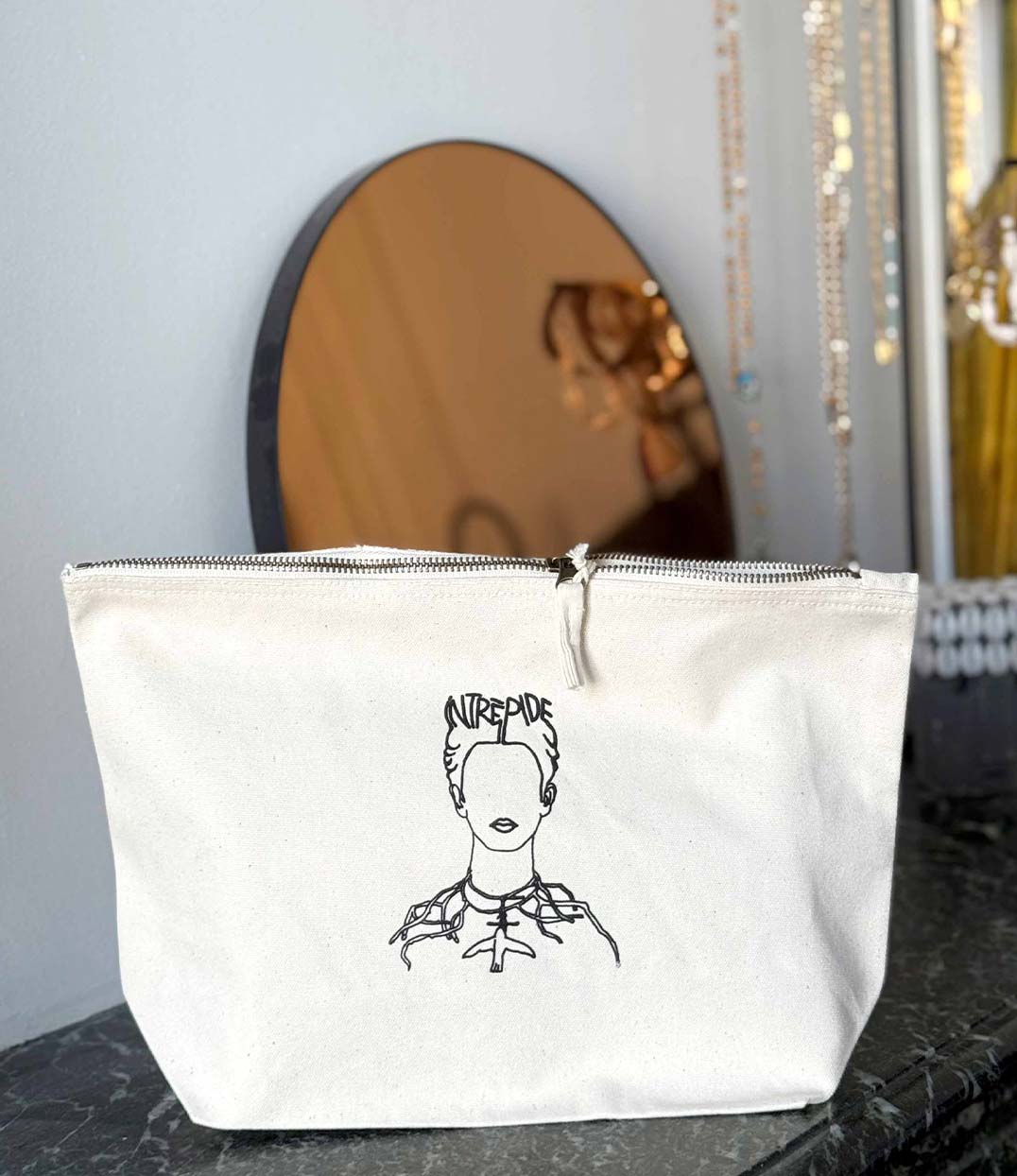 Pochette en coton bio écru, ornée d’une illustration de Frida Kahlo stylisée, symbole d’audace et d’art engagé. Modèle Frida, conçu et imprimé à Lyon par la marque éthique Leonor Roversi.