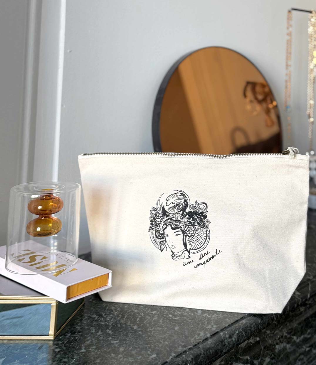 Pochette écrue en coton bio avec un imprimé noir représentant la plus grande femme samouraï accompagnée de l'inscription "âme d'une conquérante". Modèle Gozen, conçu et imprimé à Lyon par la marque éthique Leonor Roversi.