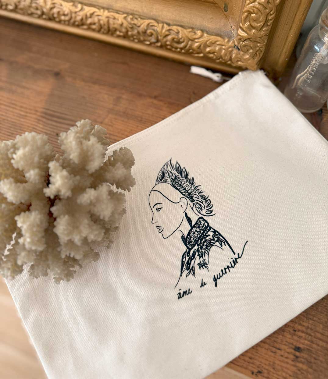Pochette en coton bio écru avec un imprimé noir d'une guerrière japonaise accompagné de l'inscription "Âme de guerrière". Modèle Benten, imprimé à Lyon par la marque éthique Leonor Roversi.