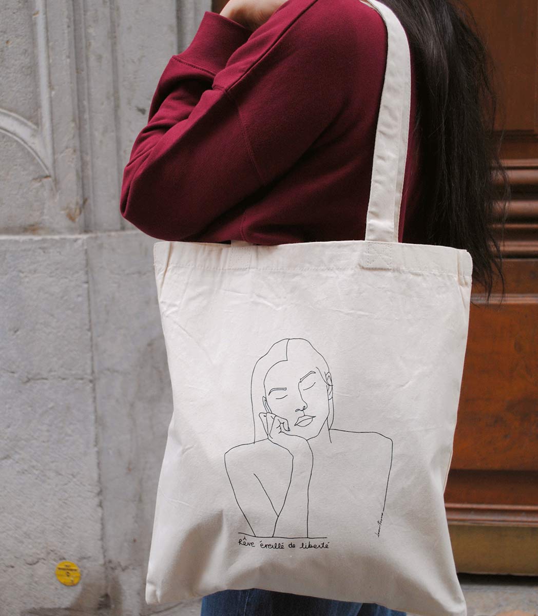 Tote bag THÉMIS Leonor Roverssi en coton bio et polyester recyclé, illustration féminine minimaliste inspirée de la déesse grecque de la justice, sérigraphiée de manière éco-responsable à Lyon. Sac éthique symbole d’équilibre et d’impartialité.