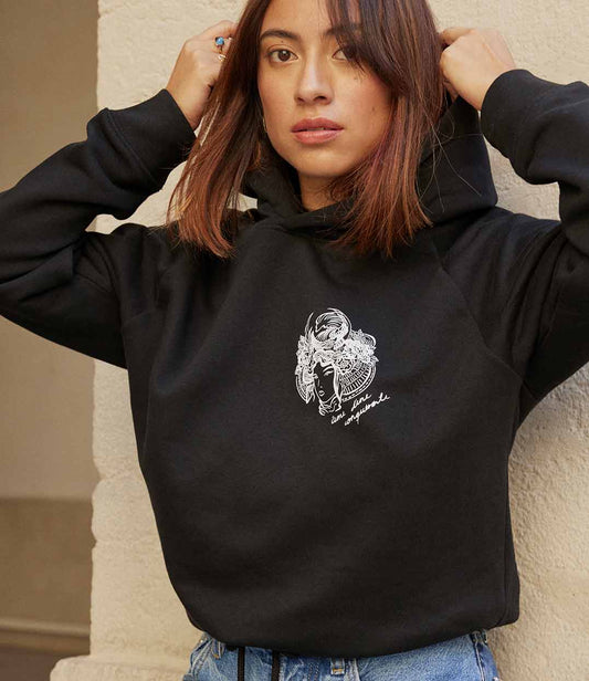 Gros plan sur une femme portant un hoodie noir en coton bio avec un imprimé blanc représentant une femme samouraï, avec l'inscription "âme d'une guerrière". Modèle Gozen, conçu et imprimé à Lyon par la marque éthique Leonor Roversi.