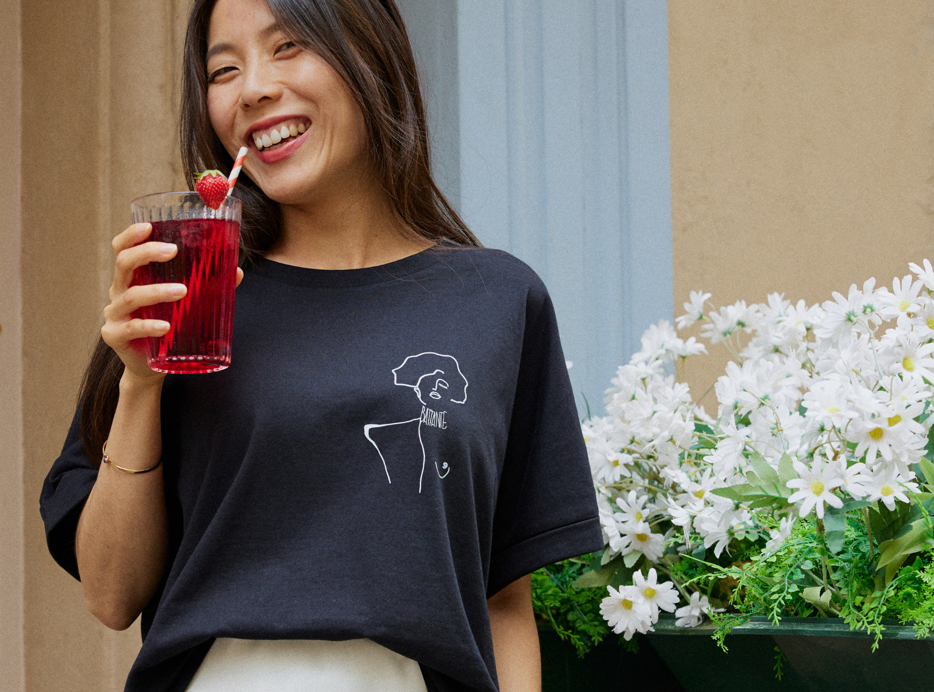 femmes buvant un sirop devant des fleurs portant un t-shirt Klimt collection Leonor Roversi 