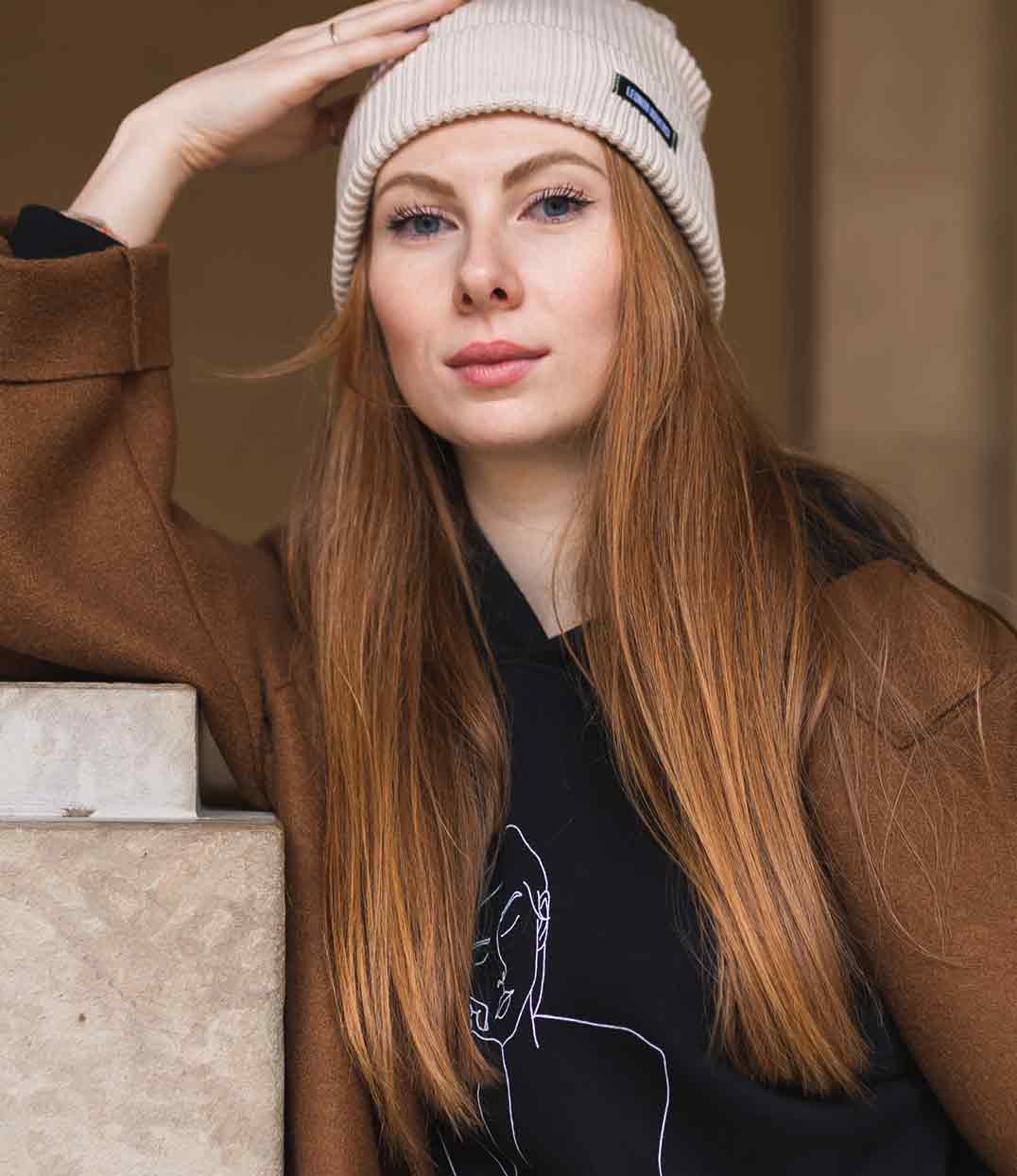 Personne portant un bonnet éthique en coton biologique certifié GOTS et FairWear, bonnet doux et tendance pour l’automne et l’hiver, bord pliable, taille unique, plusieurs coloris disponibles.