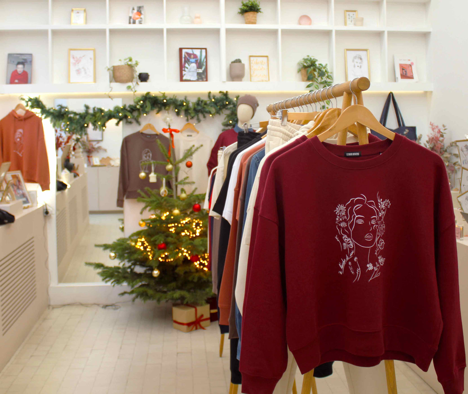 Intérieur de la boutique lyonnaise Leonor Roversi, espace engagé dédié à la mode éthique. Sweats féminins en coton bio exposés sur portants, ambiance chaleureuse et responsable, créations engagées imaginées et fabriquées à Lyon.
