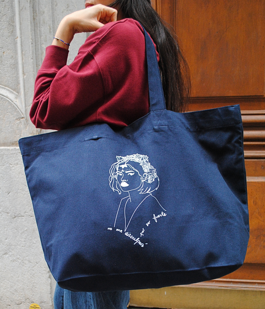 Cabas LUPITA tenu à la main par une personne, tote bag éthique et responsable en coton bio et polyester recyclé, impression sérigraphique éco-responsable à Lyon, sac grand format pour usage quotidien.

