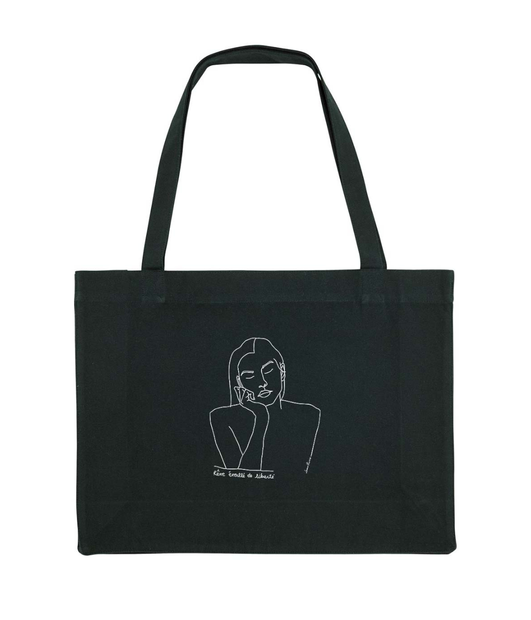Cabas en coton bio écru, imprimé noir d'un dessin minimaliste représentant une femme sereine aux yeux fermés, accompagné de la phrase manuscrite "Rêve éveillé de liberté". Modèle Thémis, imprimé à Lyon par la marque éthique Leonor Roversi.