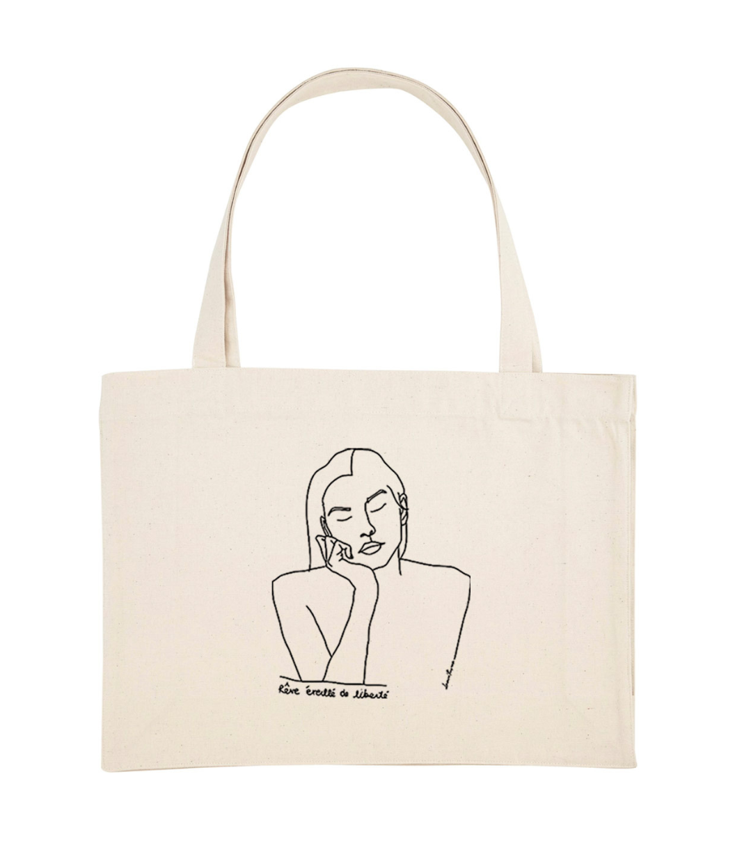 Cabas en coton bio écru, imprimé noir d'un dessin minimaliste représentant une femme sereine aux yeux fermés, accompagné de la phrase manuscrite "Rêve éveillé de liberté". Modèle Thémis, imprimé à Lyon par la marque éthique Leonor Roversi.