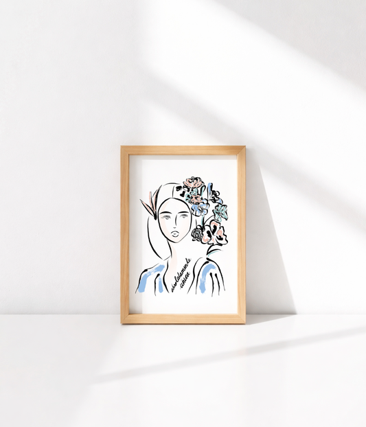 Carte postale illustrée d'une femme au regard serein entourée de fleurs roses et d'un oiseau dans les cheveux accompagnée de l'inscription "Absolumente única" posée sur une enveloppe kraft avec une branche. Modèle Unica en collaboration avec La Sigalerie, conçue et imprimée à Lyon par la marque éthique Leonor Roversi.