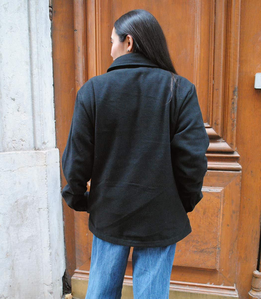 Veste ALMA LIBRE Leonor Roversi en polyester recyclé certifié GOTS et FairWear, coupe droite noirf, portée par une femme confiante. Vêtement éthique brodé à Lyon, inspiré de la liberté intérieure et de la résilience féminine.