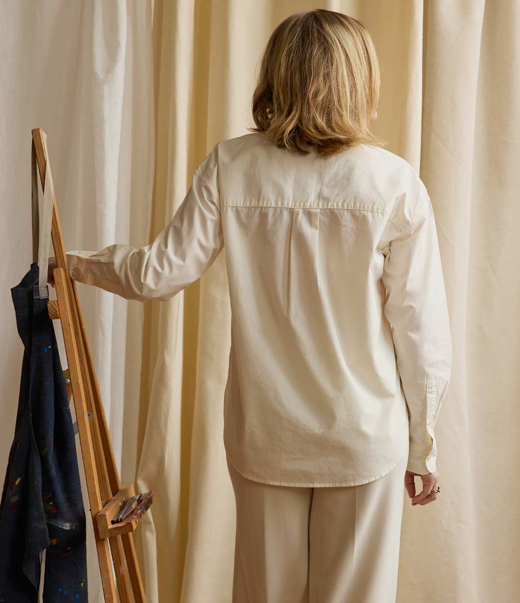 Vue de dos d'une femme portant une chemise écru en coton. Modèle Valiente conçu et imprimé à Lyon par la marque éthique Leonor Roversi.