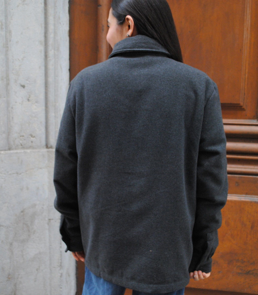 Veste ALMA LIBRE Leonor Roverssi en polyester recyclé certifié GOTS et FairWear, coupe droite gris foncé, portée par une femme confiante. Vêtement éthique brodé à Lyon, inspiré de la liberté intérieure et de la résilience féminine.