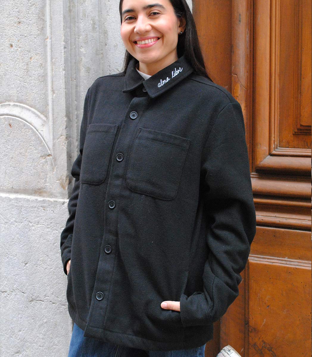 Veste ALMA LIBRE Leonor Roversi en polyester recyclé certifié GOTS et FairWear, coupe droite noirf, portée par une femme confiante. Vêtement éthique brodé à Lyon, inspiré de la liberté intérieure et de la résilience féminine.