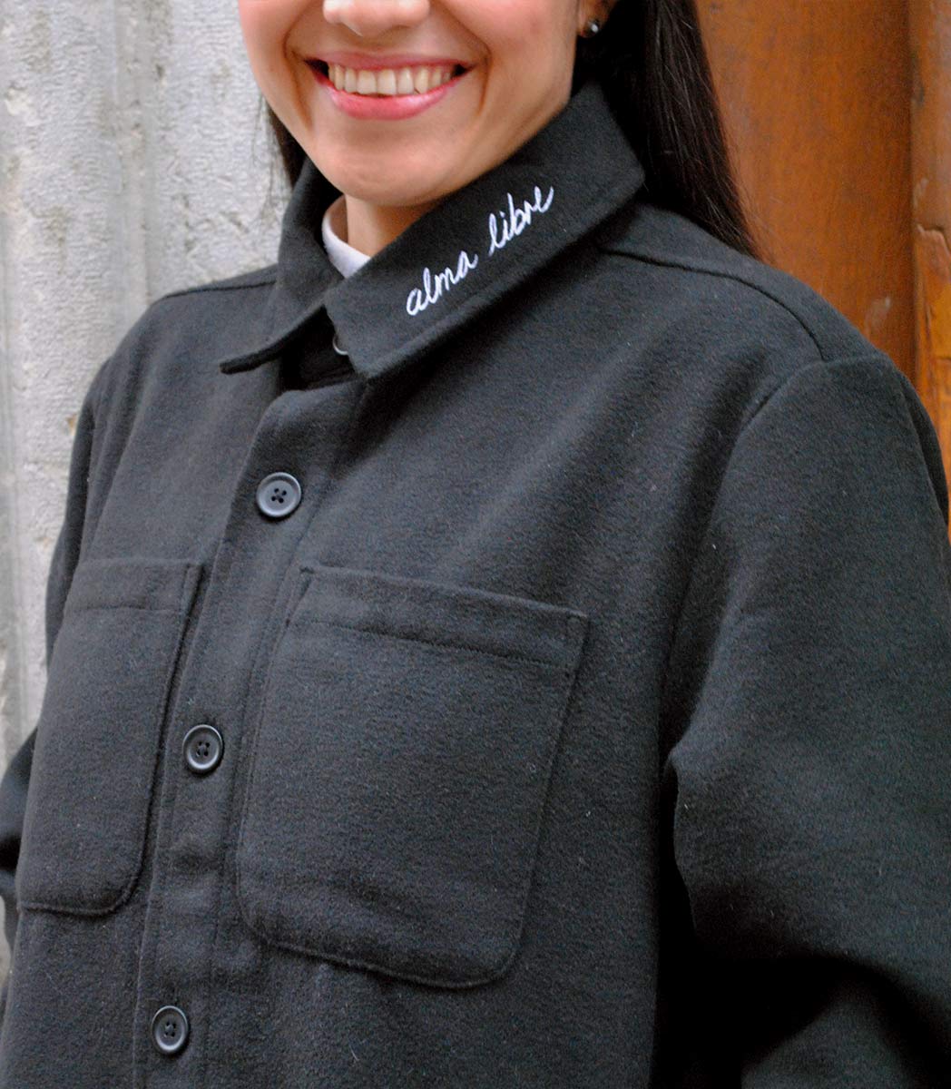 Veste ALMA LIBRE Leonor Roversi en polyester recyclé certifié GOTS et FairWear, coupe droite noirf, portée par une femme confiante. Vêtement éthique brodé à Lyon, inspiré de la liberté intérieure et de la résilience féminine.