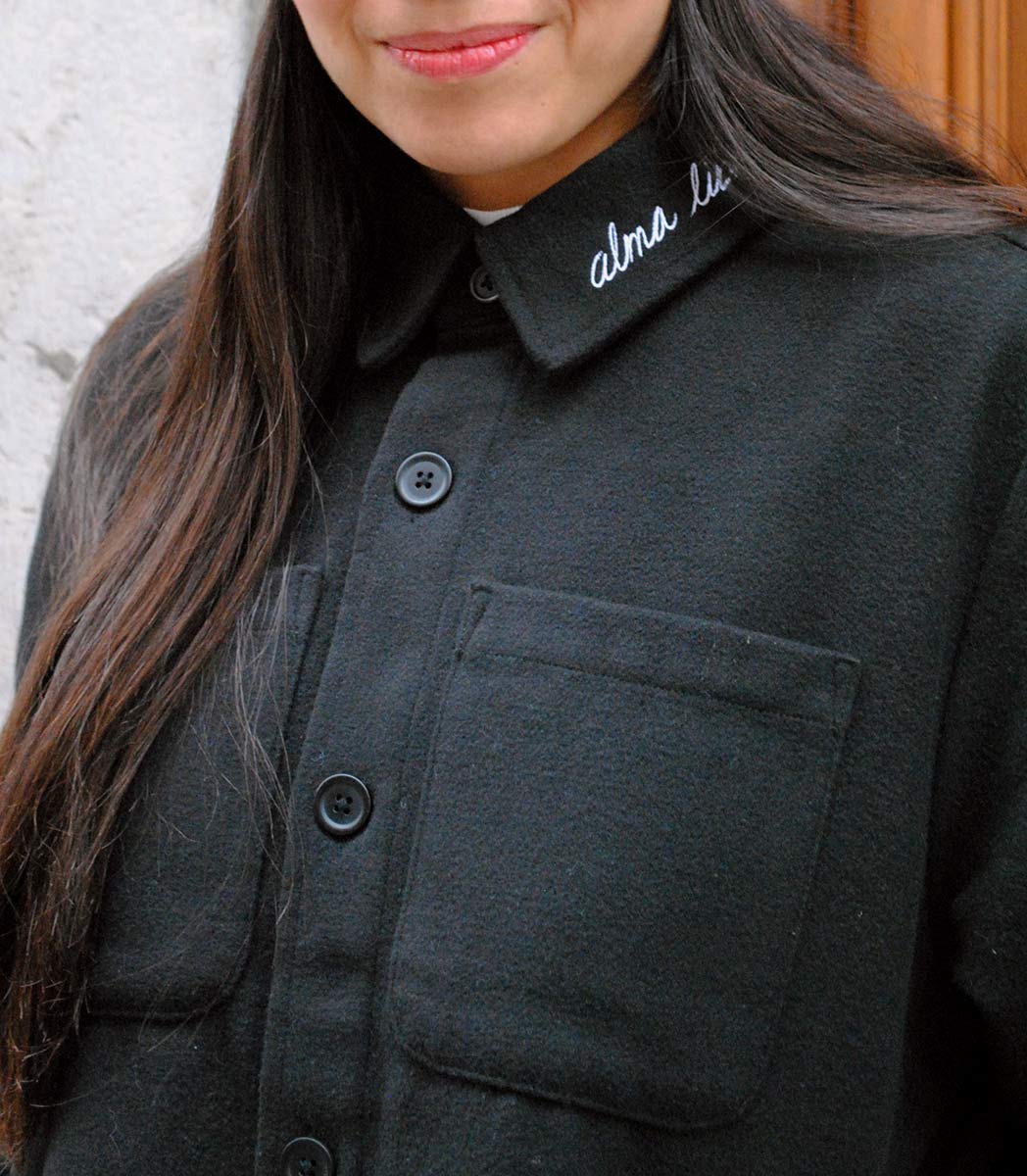Veste ALMA LIBRE Leonor Roversi en polyester recyclé certifié GOTS et FairWear, coupe droite noirf, portée par une femme confiante. Vêtement éthique brodé à Lyon, inspiré de la liberté intérieure et de la résilience féminine.