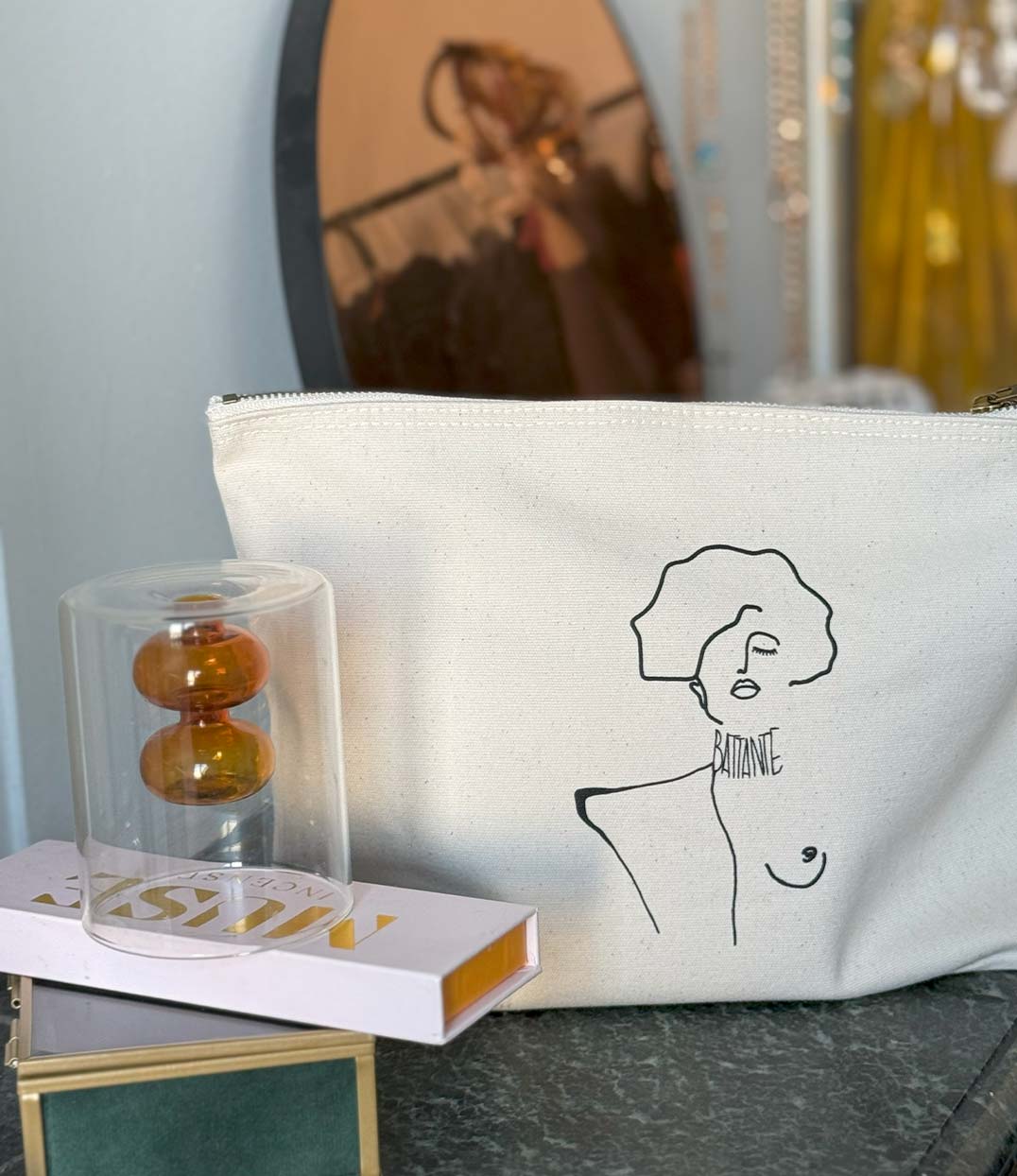 Pochette écru en coton bio avec un imprimé noir représentant une femme forte inspirée du tableau de Gustav Klimt avec l'inscription "Battante". Modèle Klimt, conçu et imprimé à Lyon par la marque éthique Leonor Roversi.