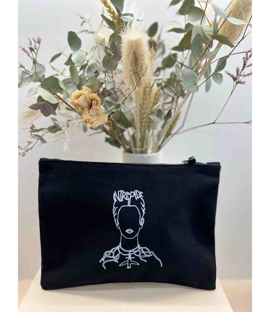 Pochette en coton bio noir, imprimé blanc d'une représentation de Frida Kahlo accompagnée de l'inscription "Intrépide". Modèle Intrépide, conçu et imprimé à Lyon par la marque éthique Leonor Roversi.