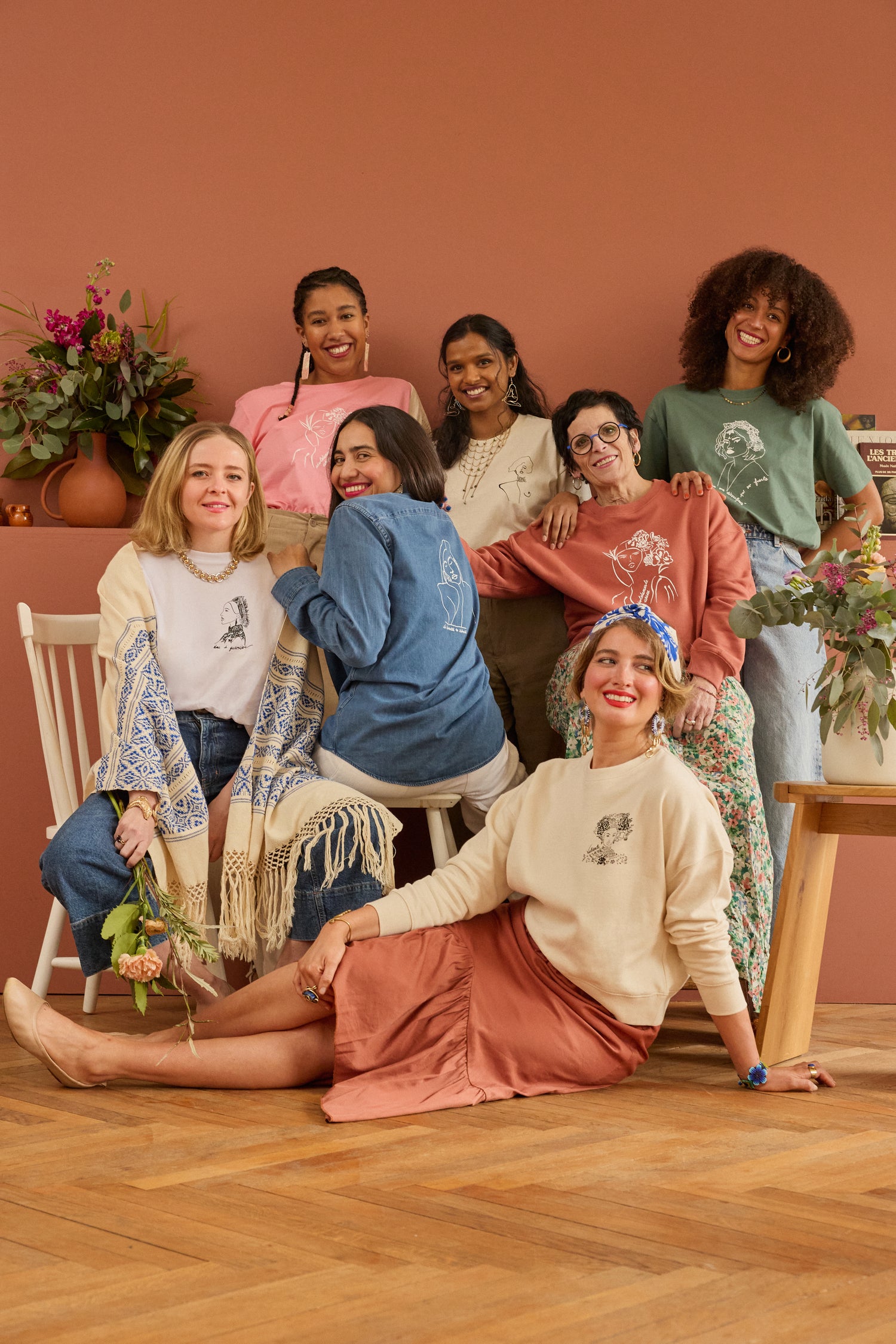 Sept femmes souriantes portant des hauts de la marque lyonnaise et éthique Leonor Roversi. Chaque haut est illustré de femmes inspirantes. Modèle Valiente, Benten, Thémis, Unica, Klimt et Lupita. Conçu et imprimé à Lyon par la marque éthique Leonor Roversi.