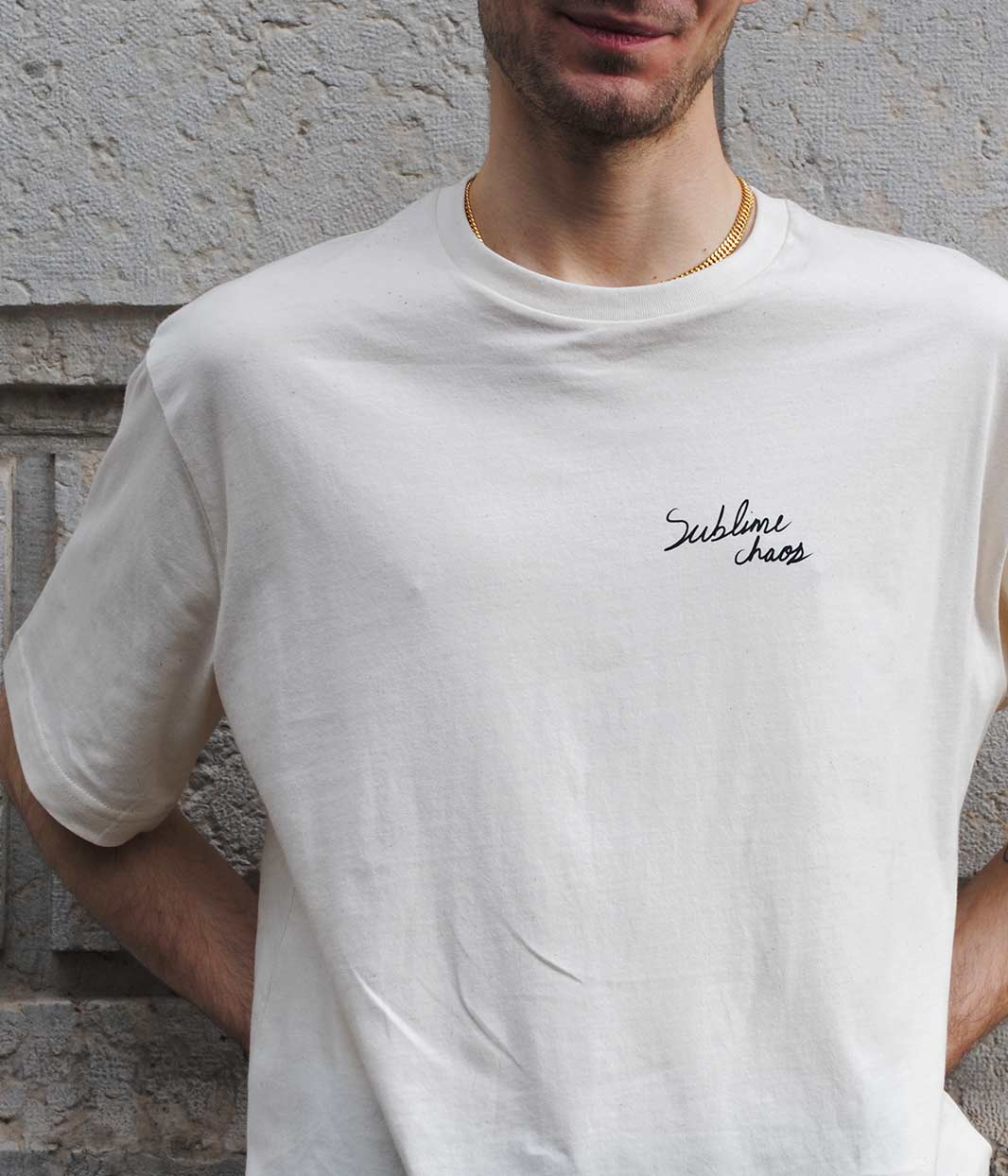 Personne photographiée de face portant un t-shirt bordeaux unisexe oversize en coton bio. Le vêtement présente à l’avant une inscription blanche discrète « Sublime Chaos », brodée ou sérigraphiée au niveau de la poitrine. Une pièce minimaliste et engagée, sérigraphiée de manière artisanale et éthique à Lyon par la marque lyonnaise Leonor Roversi, inspirée de la philosophie japonaise Wabi Sabi célébrant l’imperfection et l’authenticité.