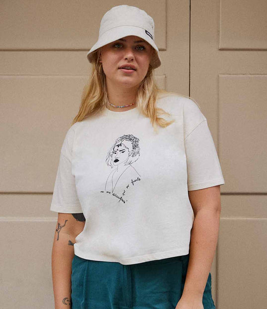 T-shirt femme en coton bio écru avec un imprimé noir représentant une femme forte inspirée d’une reine d’Amérique latine, accompagné de l’inscription “No me disculparé por ser fuerte”. Modèle Lupita, imprimé à Lyon par la marque éthique Leonor Roversi.
