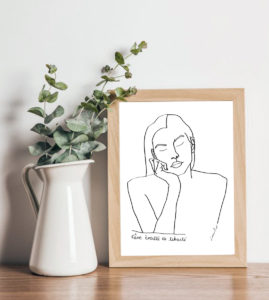 Image d'un cadre avec l’affiche A4 d’une femme qui rêve, Themis, à côté d'un pot avec des eucalyptus artificiels