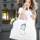 Une femme portant un sac cabas crème de la collection reines de la marque lyonnaise féministe éthique et éco-responsable Leonor roversi
