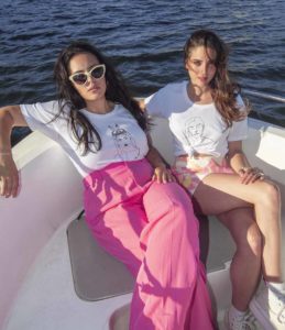 Deux femmes sur un bateau portant des t-shirts Leonor Roversi