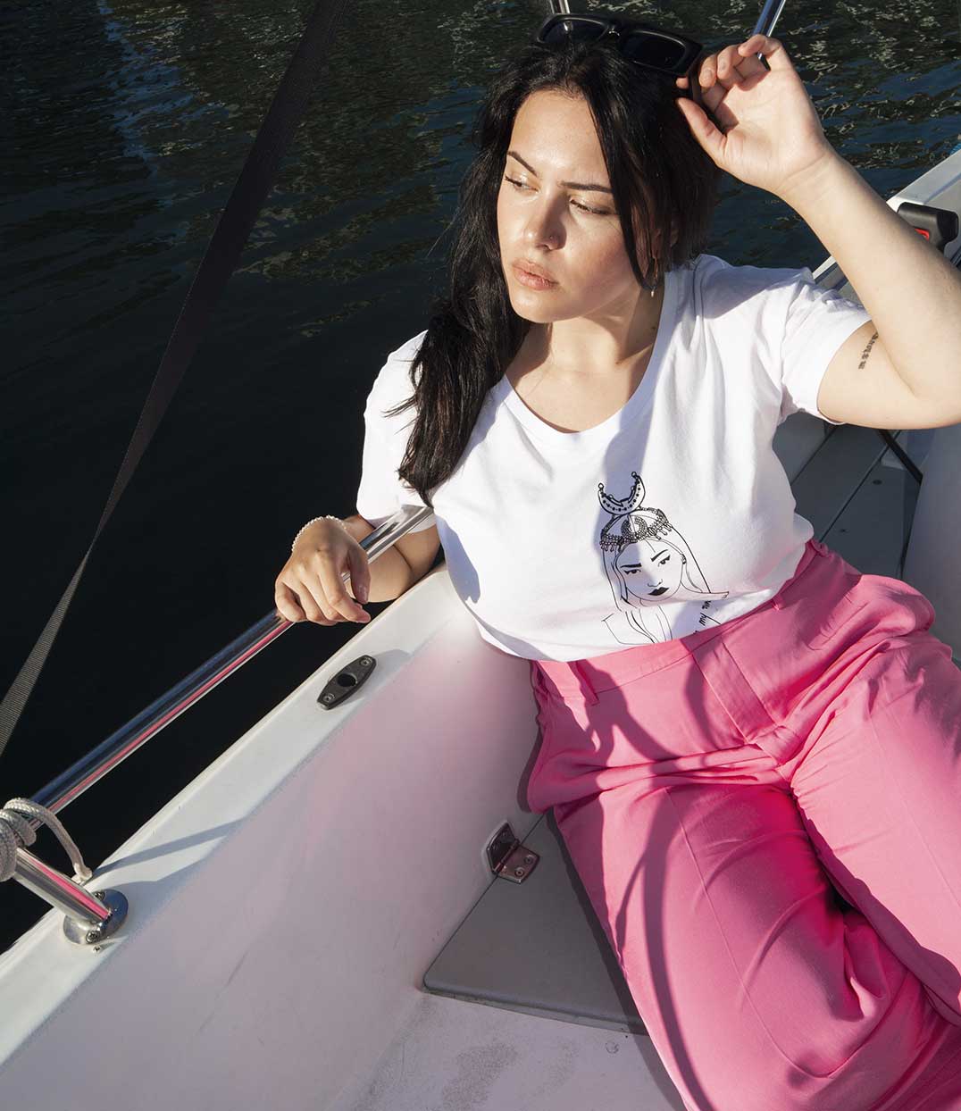 Femme sur un bateau portant le t-shirt blanc coyoqui Leonor Roversi