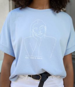 Une femme portant un t-shirt loose bleu clair de la collection diosas Themis de la marque lyonnaise féministe éthique éco-responsable LEONOR ROVERSI