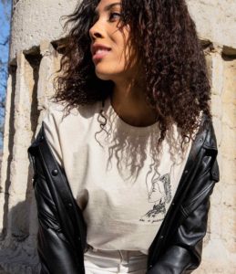 Femme portant un t-shirt crème de la nouvelle collection taka de Leonor Roversi