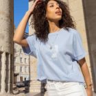 Femme portant t-shirt bleu clair avec un motif de la nouvelle collection TAKA de la marque Leonor Roversi