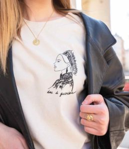 Femme portant un t-shirt crème avec illustration âme de guerrière de la nouvelle collection TAKA de la marque Leonor Roversi