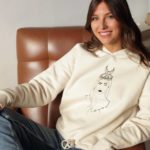 femme portant hoodie crème sur un fauteuil