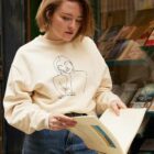 Femme portant le sweatshirt Themis naturel qui lit un livre