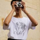 femme debout prenant des photos porte un tshirt blanc unica leonor roversi