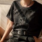 T-shirt noir Themis porté par une femme assise