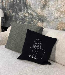 Coussin noir Thémis de la marque Leonor Roversi sur un canapé